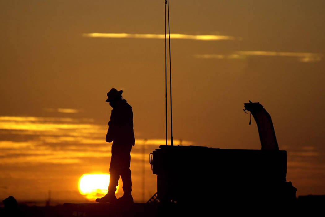 The sun sets on an American soldier at the Kandahar airport in Afghanistan in 2001. (AP Photo/E ...