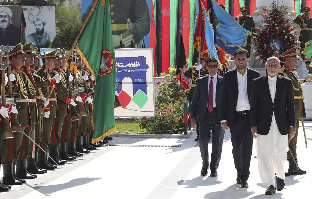 In this photo released by the Afghan Presidential Palace, Afghan President Ashraf Ghani, right, ...