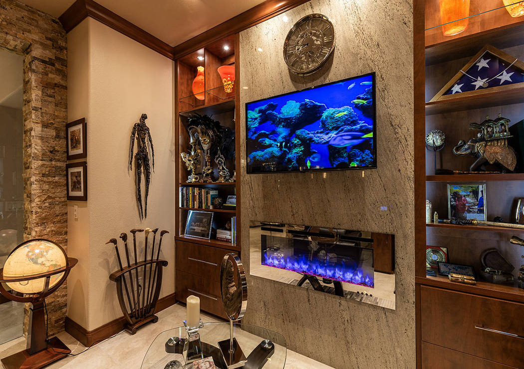Instead of the 350-gallon freshwater fish tank at their old home, there is a television set int ...