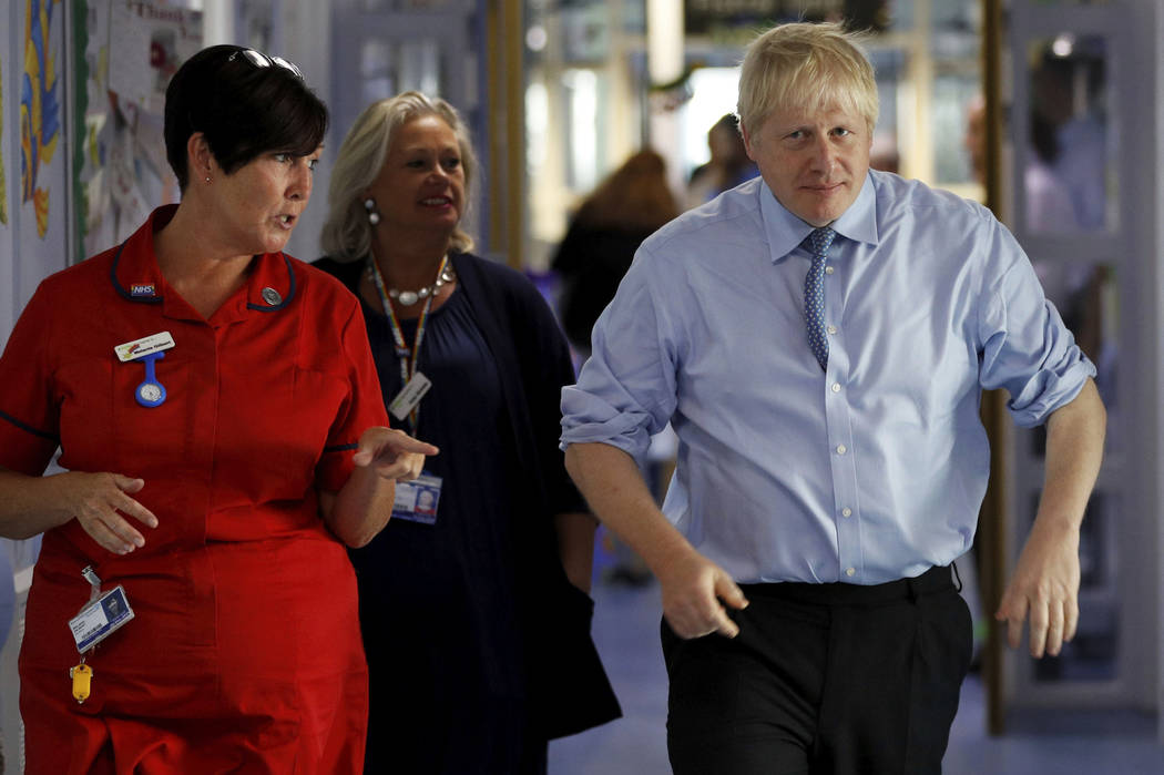 Britain's Prime Minister Boris Johnson is guided during a visit to the Royal Cornwall Hospital ...