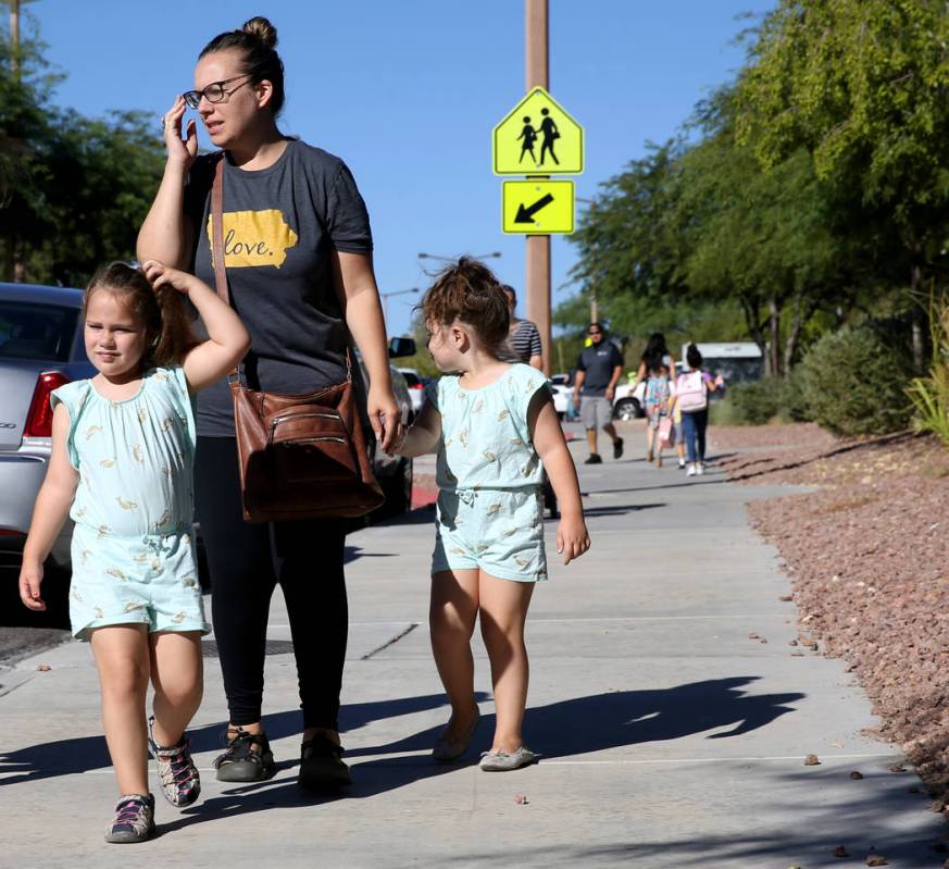 Melissa Kendal talks to a reporter with her twins Lucie and Charlotte, 4, at Staton Elementary ...