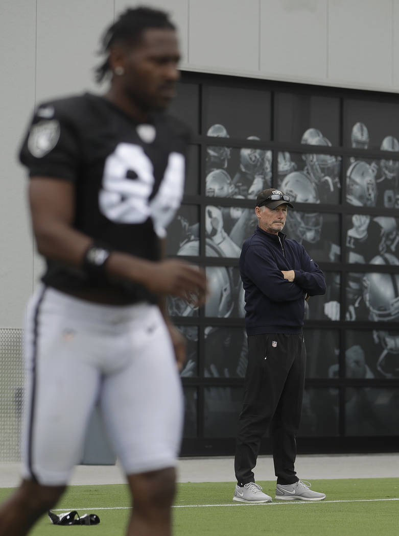 Oakland Raiders general manager Mike Mayock, right, watches while players stretch as Antonio Br ...