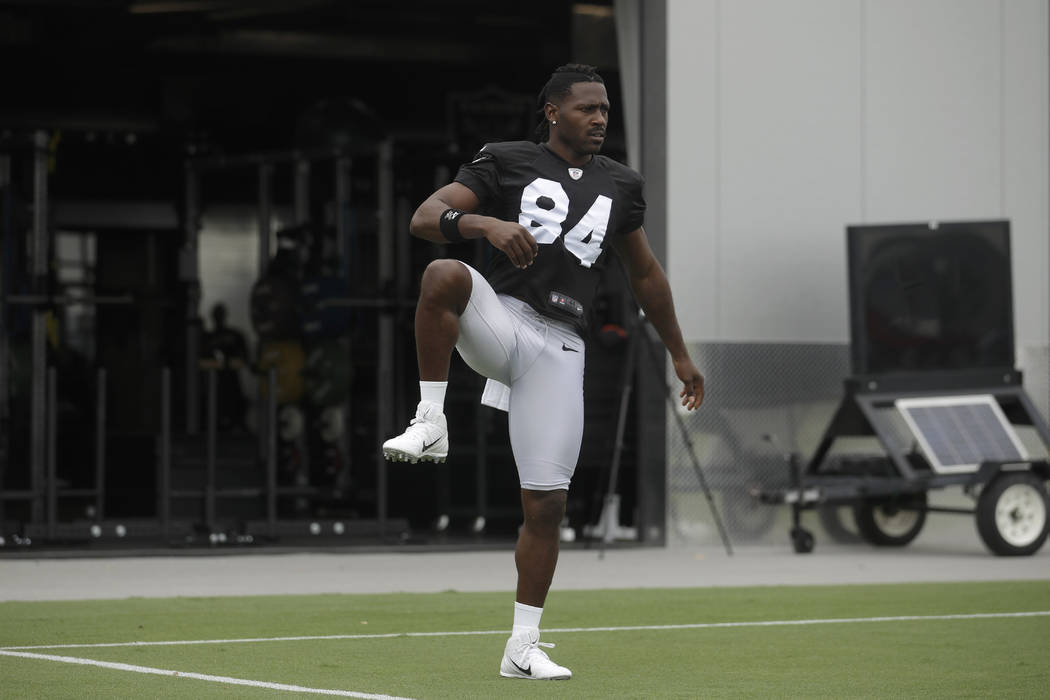 Oakland Raiders' Antonio Brown stretches during NFL football practice in Alameda, Calif., Tuesd ...