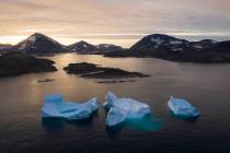 In an Aug. 16, 2019, photo, large Icebergs float away as the sun rises near Kulusuk, Greenland. ...