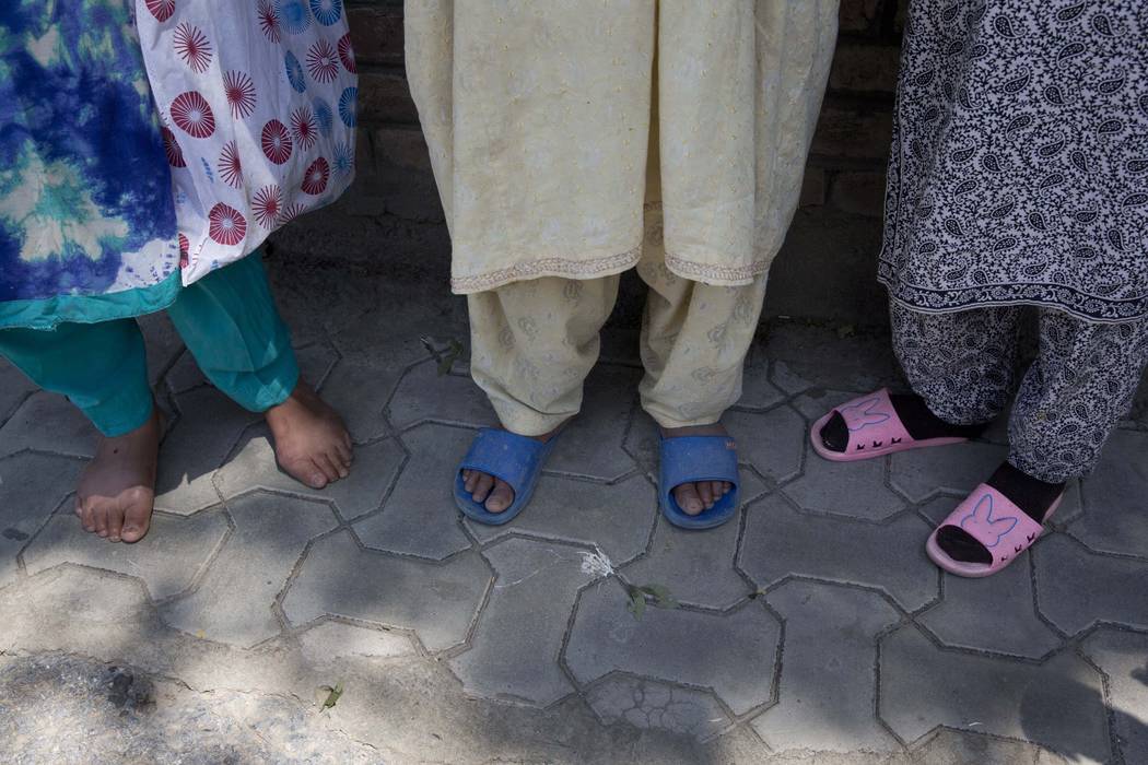 Kashmiri women stand outside a police station waiting to hear about their relatives who were d ...
