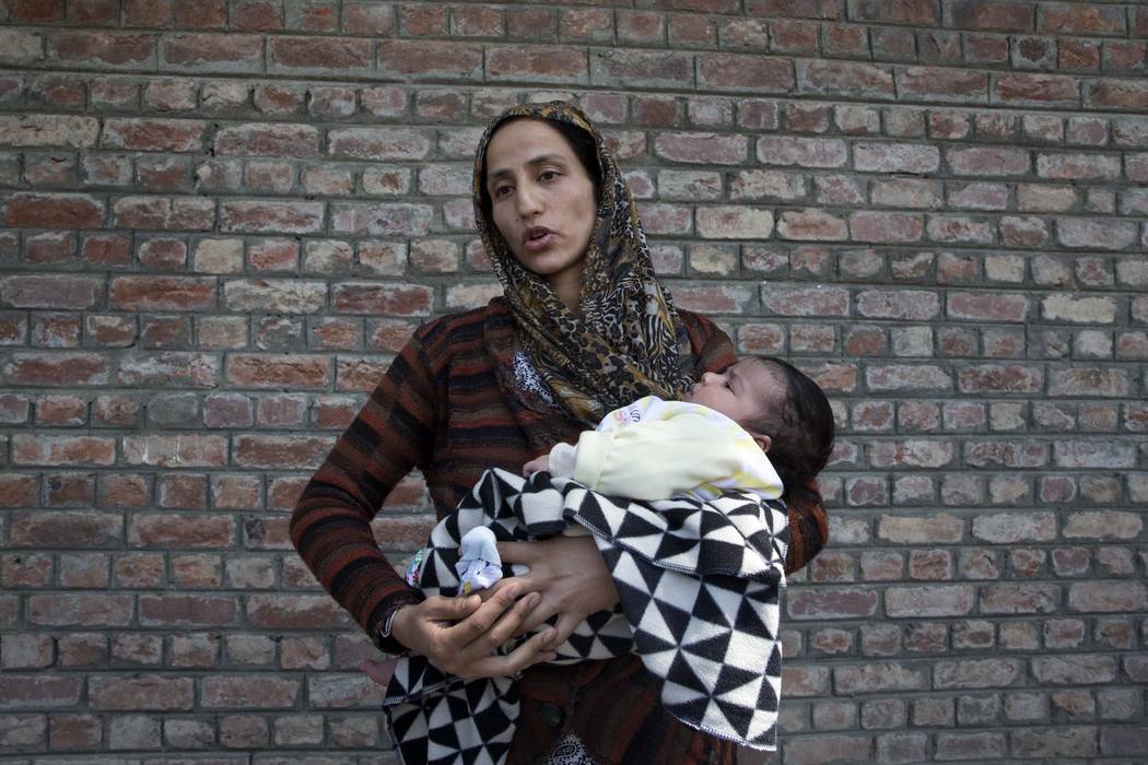 Ulfat, a Kashmiri woman holds her forty days old daughter Tanzeela, as she waits outside a poli ...