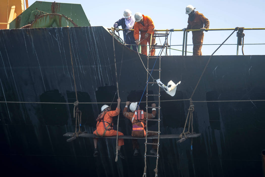 Crew members of the Grace 1 super tanker remove the name of ship in the British territory of Gi ...