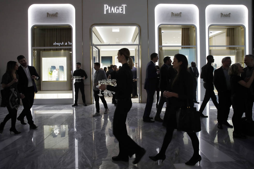 FILE- In this March 14, 2019, file photo people attend the opening of a Piaget store during the ...