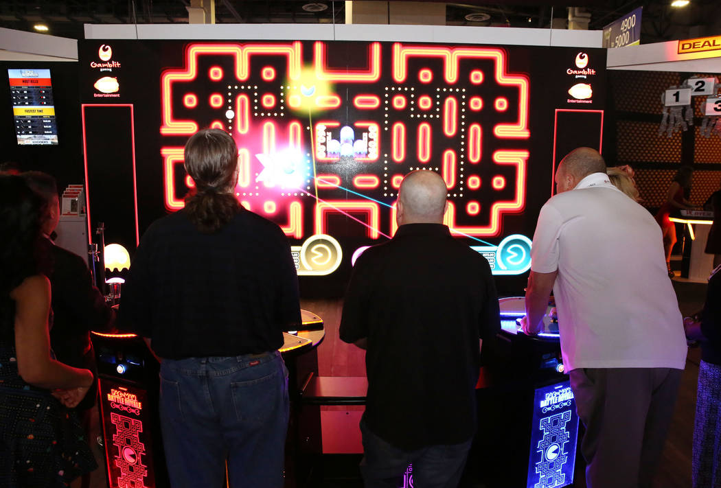 Expo goers play Pac-Man Battle at the Gamblit Gaming booth during Global Gaming Expo at the San ...