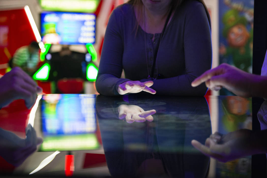 Attendees play a Deal or No Deal themed table game that uses touch screen technology at the Gam ...