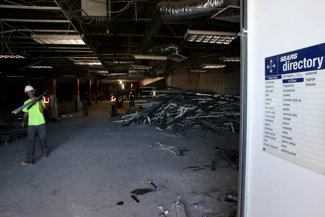 Workers, including John Duncombe, recycle building material inside the former Sears store is sh ...