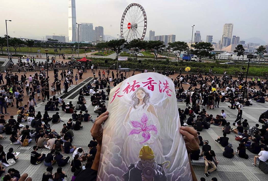 A protestor holds a sign reading "God bless Hong Kong" during a demonstration by stud ...