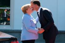 Dutch Prime Minister Mark Rutte, right, greets German Chancellor Angela Merkel in The Hague, Ne ...