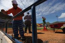 Ground workers fix the dugout of the Guatamare stadium in Porlamar at Margarita Island, Venezue ...