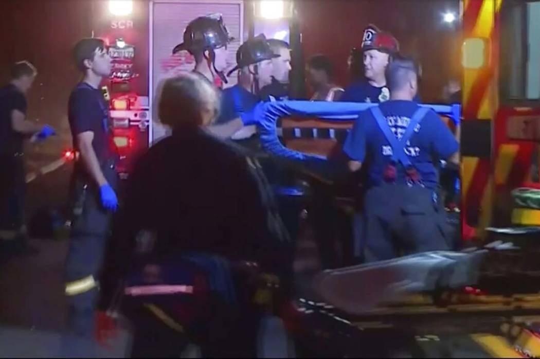 In this image from video, an emergency crew carries stretchers for injured persons after a ligh ...