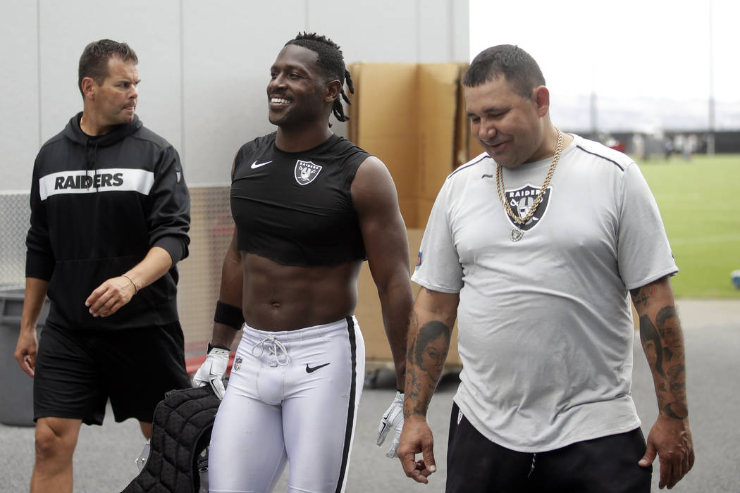 Oakland Raiders' Antonio Brown, center, walks off the field after NFL football practice in Alam ...