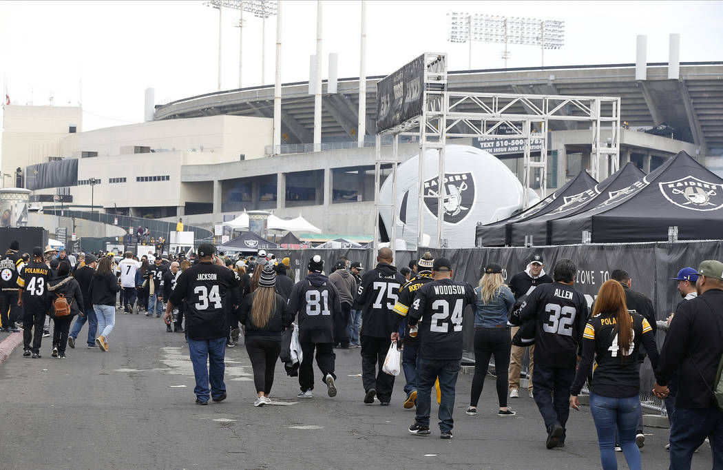 Fans tailgate outside of Oakland Alameda County Coliseum before an NFL football game between th ...