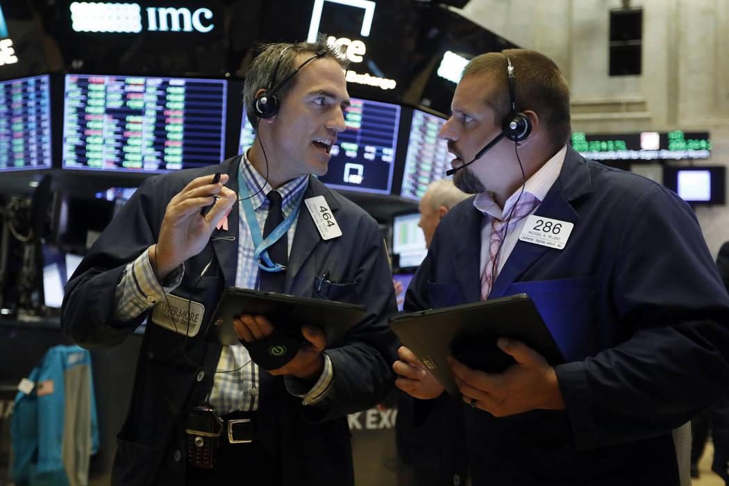 Traders Gregory Rowe, left, and Michael Milano work on the floor of the New York Stock Exchange ...