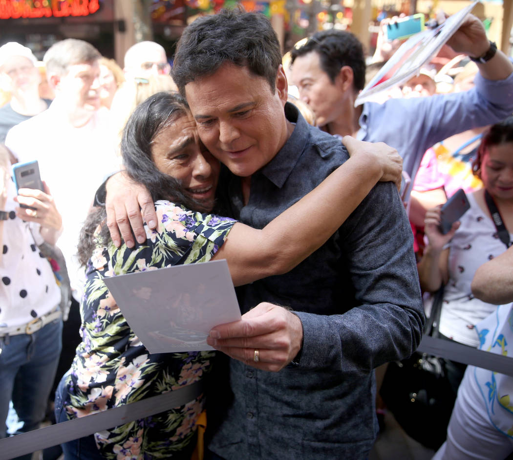 Strip headliner Donny Osmond hugs Lucie Hanna of Canoga Park, Calif. after receiving a Key to T ...