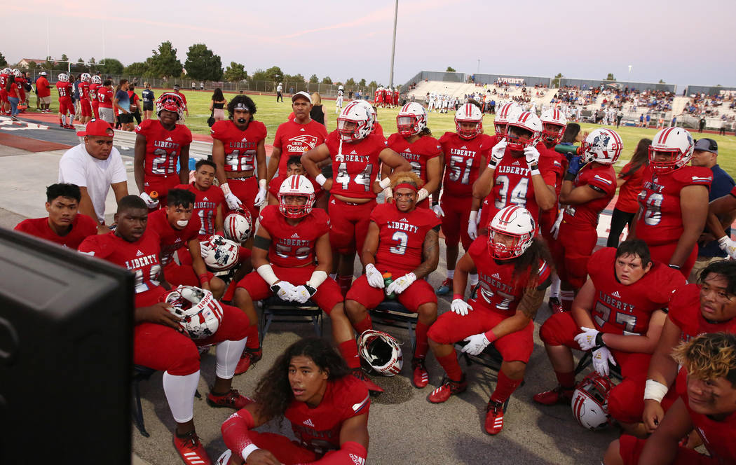 The Liberty High school football players review a play during a football game against Chandler, ...