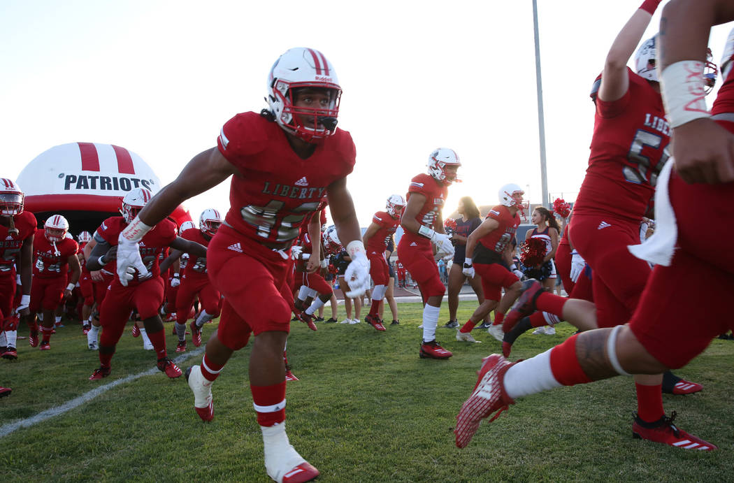 The Liberty High school football players take the field during a football game against Chandler ...