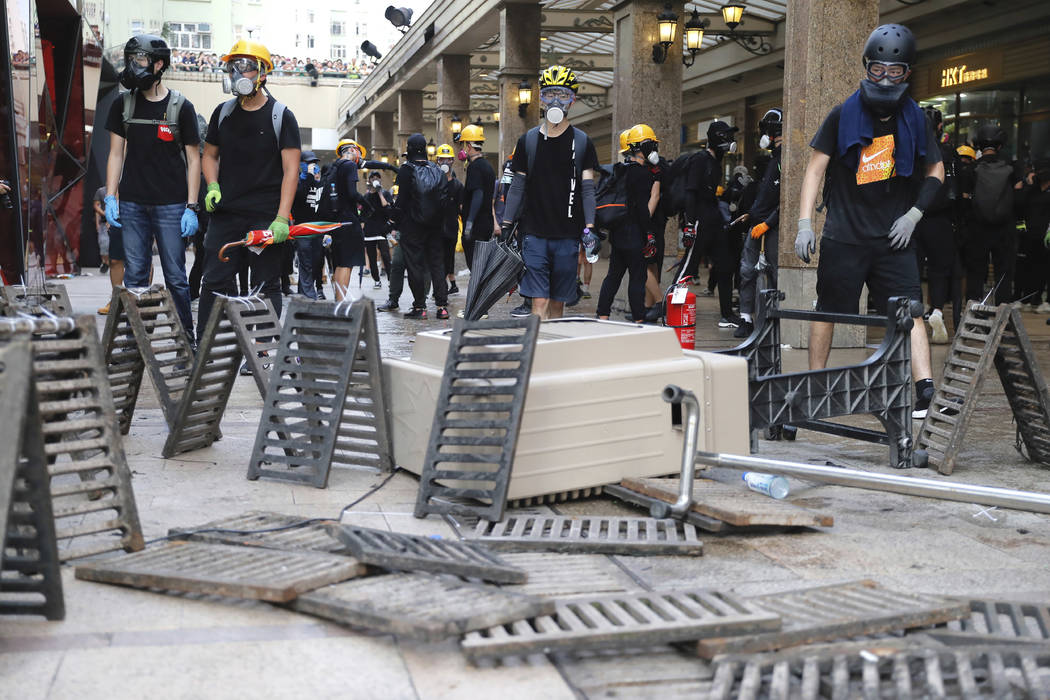 Demonstrators stand behind barricades during a protest in Hong Kong, Saturday, Aug. 24, 2019. H ...