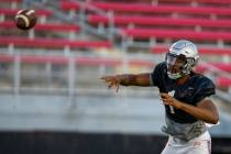 Quarterback Armani Rogers (1) passes to a receiver during the UNLV football team scrimmage at S ...