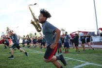Member of the Liberty High marching band Damien Alexander, front, take the field during a footb ...