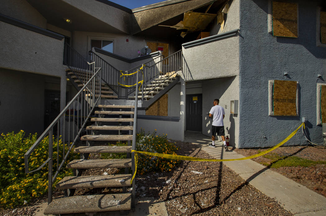 A maintenance worker heads inside a lower apartment where an early morning fire occurred at The ...