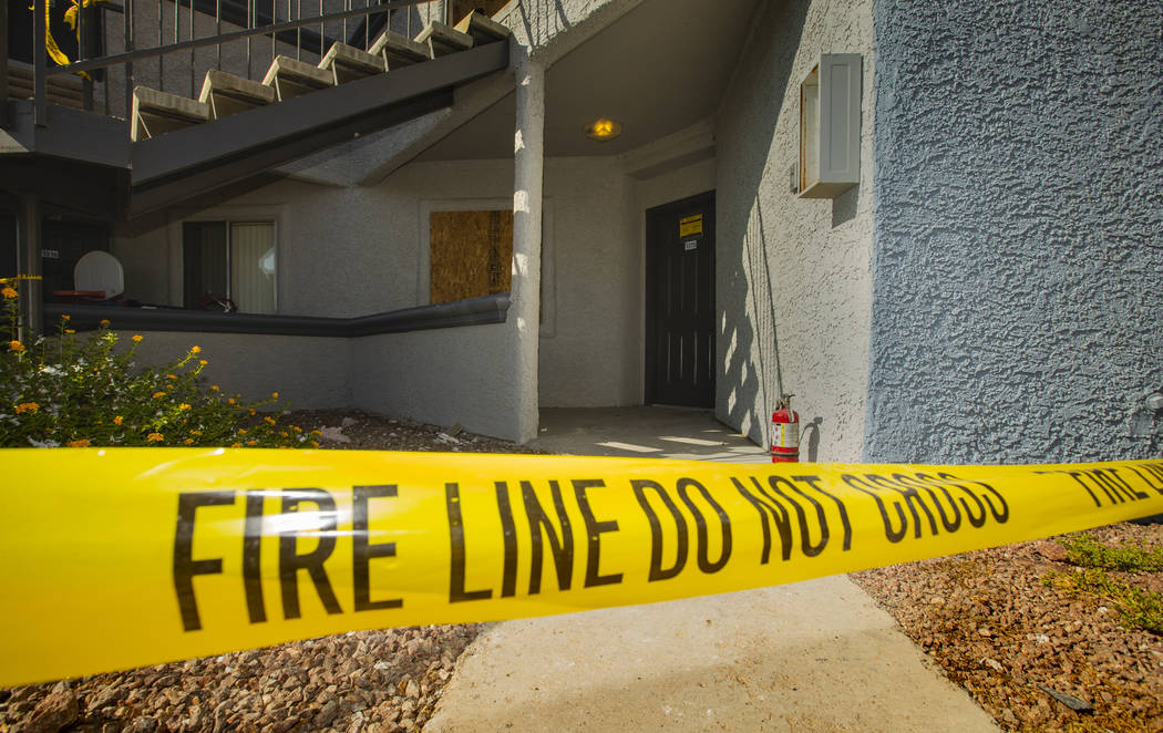 Fire department warning tape blocks the apartment entrance from an early morning fire at The Br ...