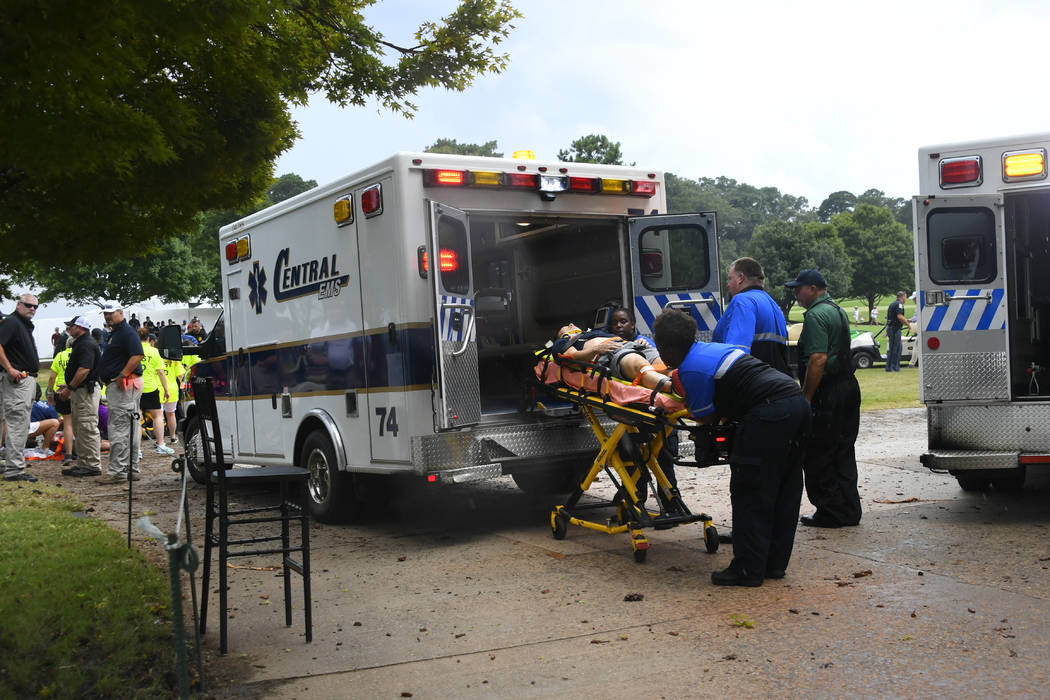 A spectator is taken to an ambulance after a lightning strike on the course which left several ...