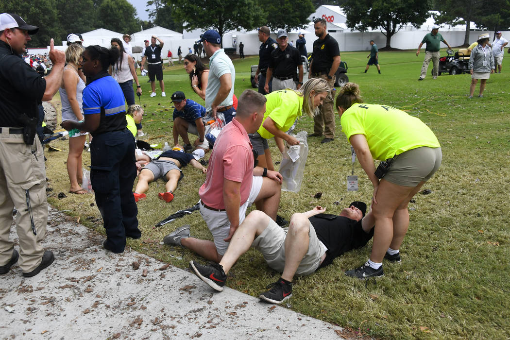 Spectators are tended to after a lightning strike on the course left several injured during a w ...