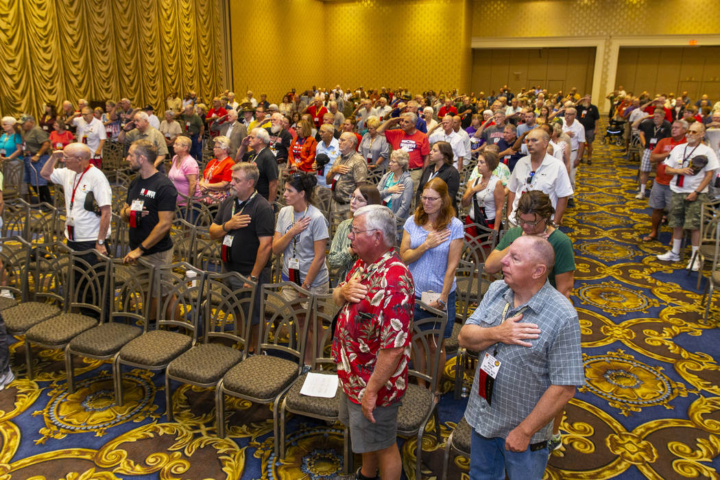 Veterans and spouses stand for "Taps" in honor of those who served in Vietnam attendi ...