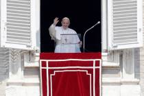 Pope Francis waves to faithful during the Angelus noon prayer in St. Peter's Square at the Vati ...