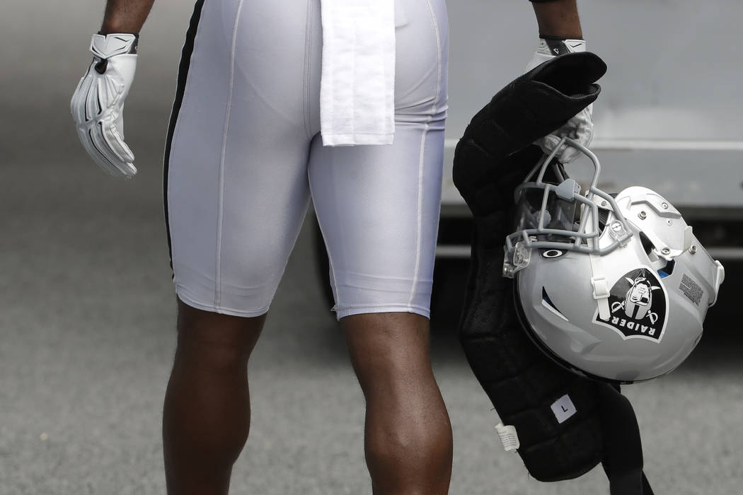 Oakland Raiders' Antonio Brown carries his helmet as he walks off the field after NFL football ...