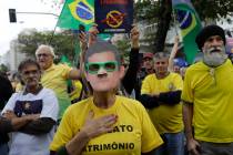 A woman wears a mask of Brazil's Justice Minister Sergio Moro during a rally in support of the ...