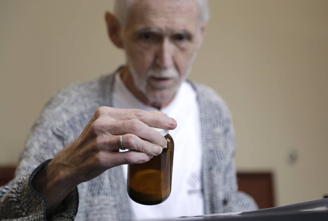 In this May 3, 2019, photo, Robert Fuller looks at the vial containing the drugs that will end ...
