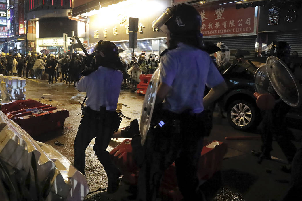 A policeman's gun was dropped on the floor, left, after clashed with demonstrators on a street ...