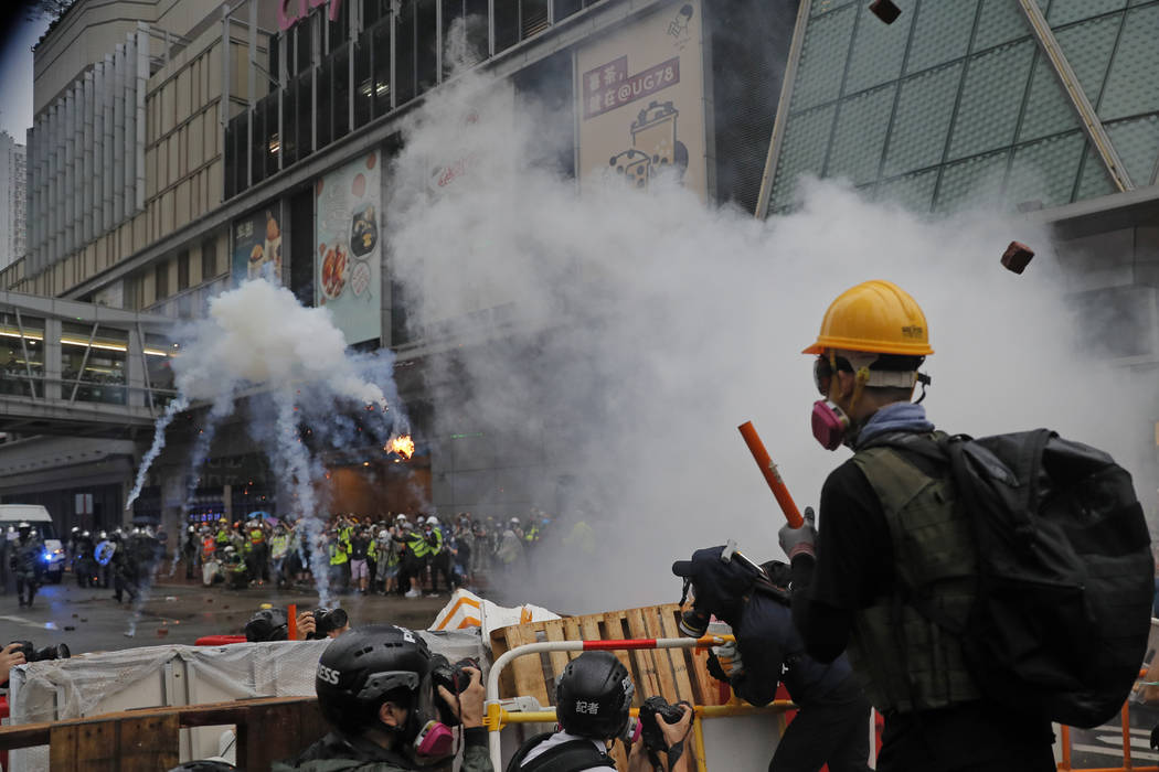 Policemen clash with demonstrators on a street during a protest in Hong Kong, Sunday, Aug. 25, ...