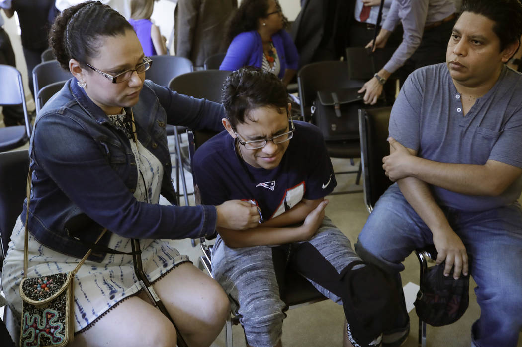 Gary Sanchez, of Honduras, right, watches as his wife, Mariela comforts their son, Jonathan, 16 ...