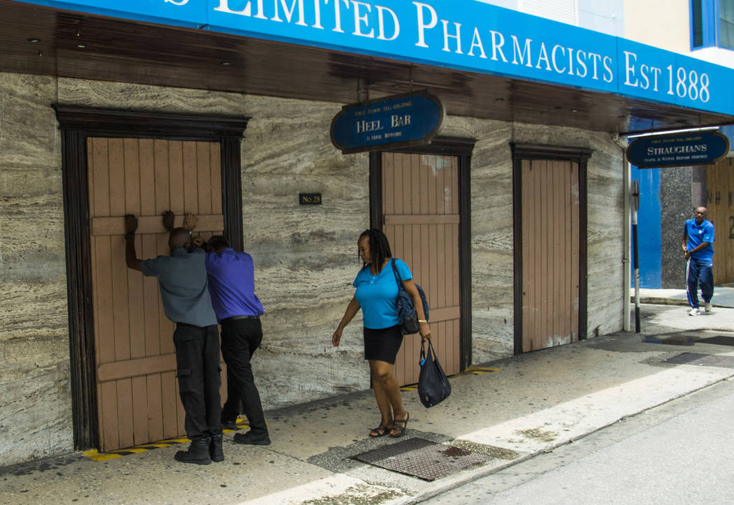 Residents board up a storefront pharmacy as they prepare for the arrival of Tropical Storm Dori ...