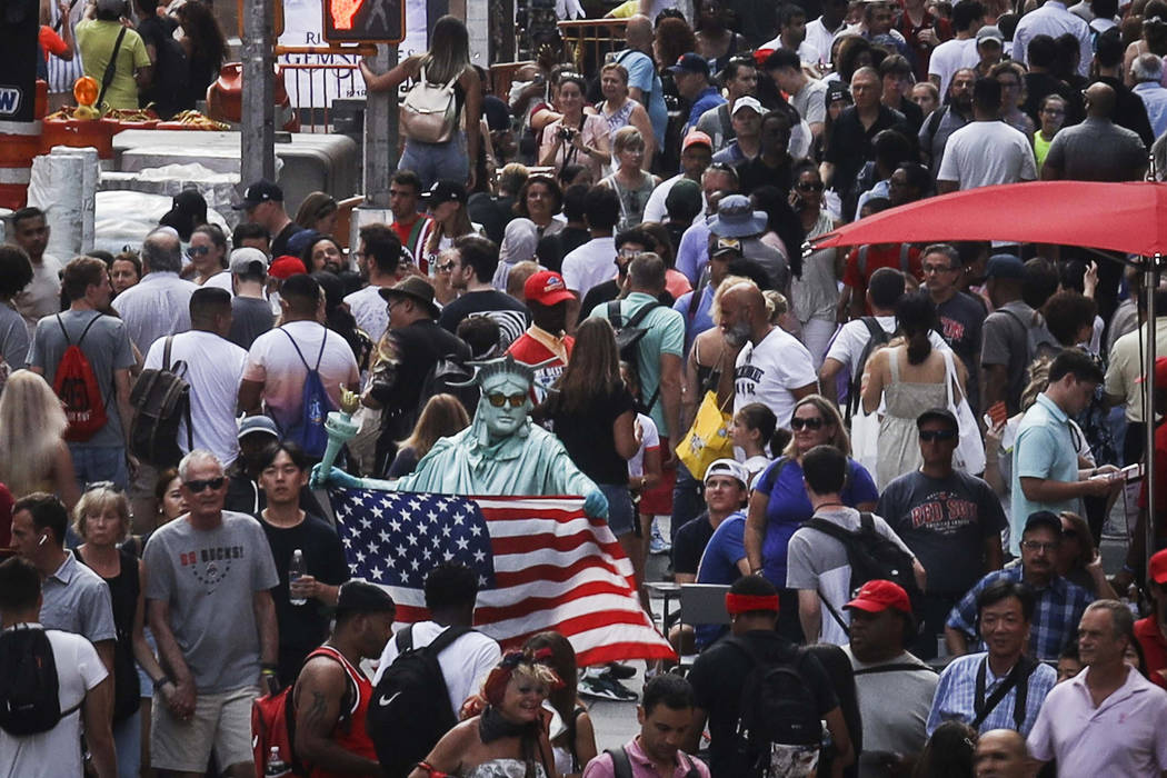 In this Aug. 22, 2019, photo, people walk through New York's Times Square. With just a few mont ...