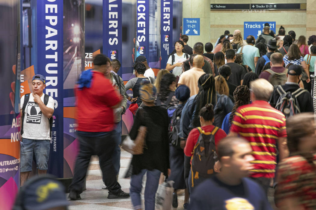 In this Aug. 23, 2019, photo, commuters pass through the New Jersey Transit train area of New Y ...