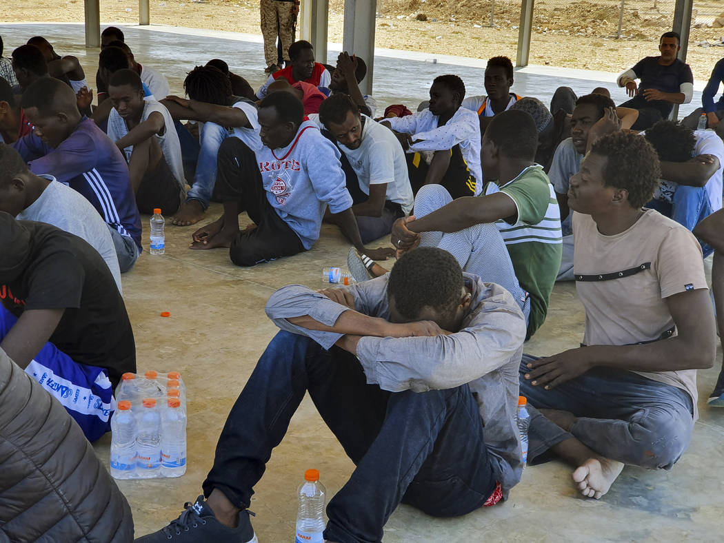 Rescued migrants rest near the city of Khoms, around 120 kilometers (75 miles) east of Tripoli, ...