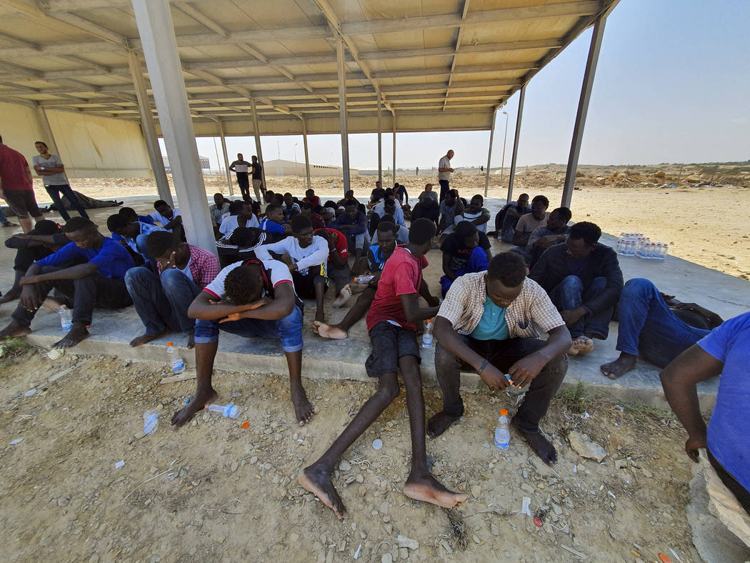 Rescued migrants rest near the city of Khoms, around 120 kilometers (75 miles) east of Tripoli, ...