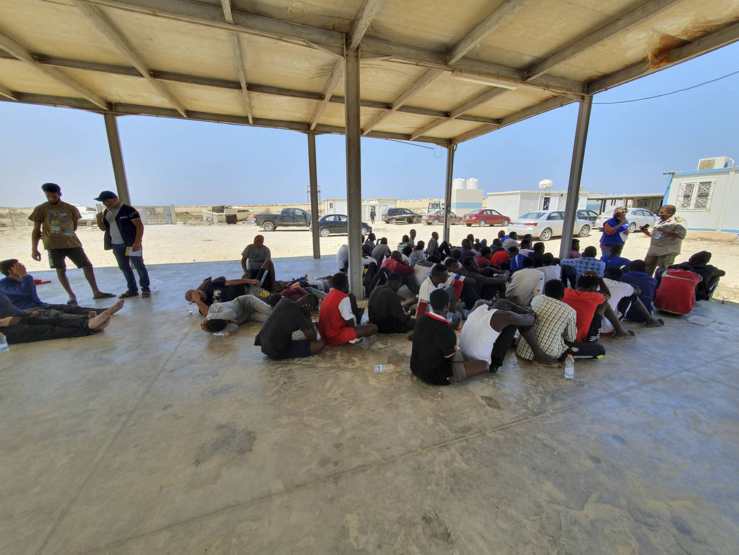 Rescued migrants rest near the city of Khoms, around 120 kilometers (75 miles) east of Tripoli, ...
