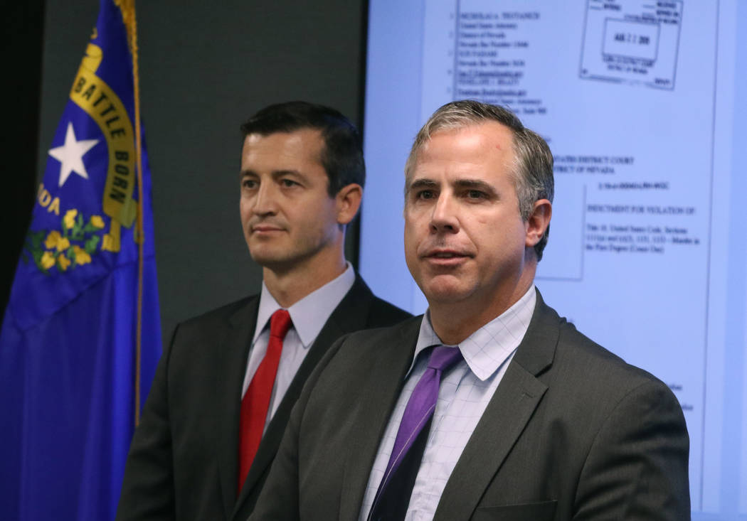 U.S. Attorney Nicholas Trutanich, left, listens as Ray Johnson, assistant special agent in char ...
