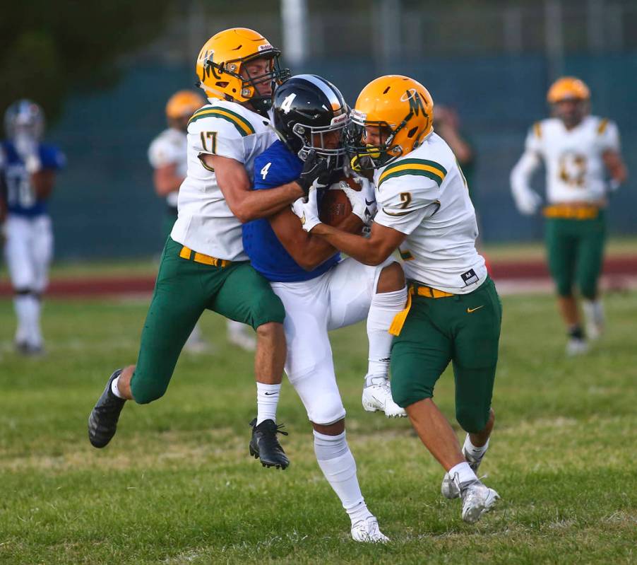 Bishop Manogue's Jaxon Enard (17) and Colby Crisp (2) take down Desert Pines' Branden Thomas (4 ...