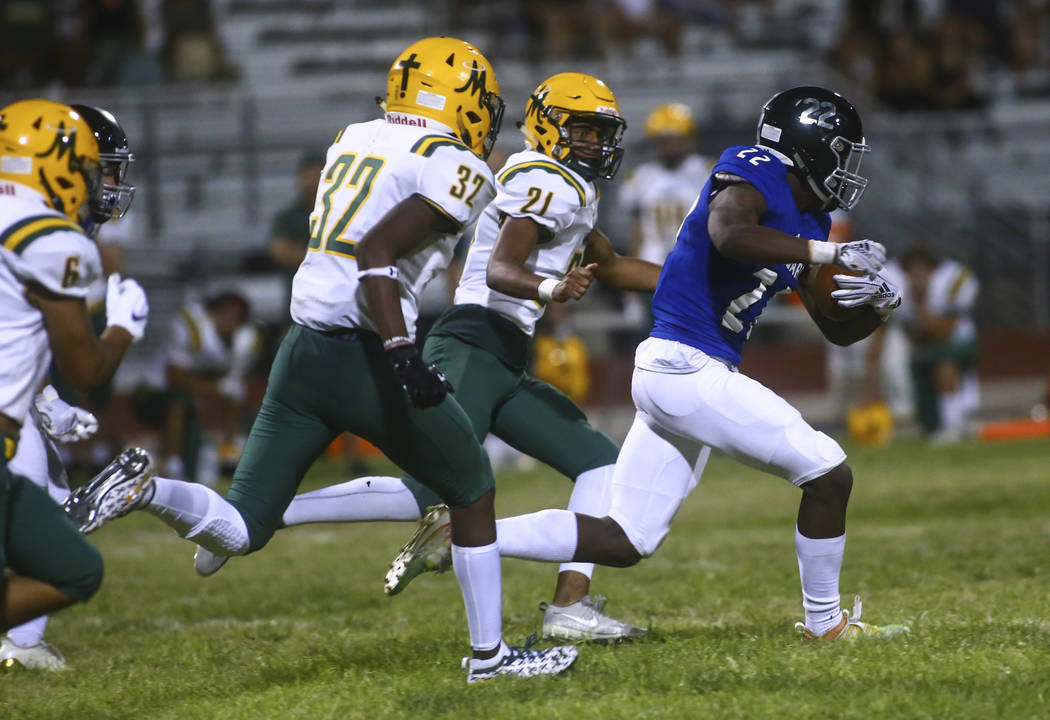 Desert Pines' Javontae Barnes (22) runs the ball past Bishop Manogue's Kaeden Howell (21) durin ...