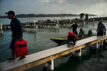 People arrive to a private harbor to move boats away for protection ahead of the arrival of Tro ...